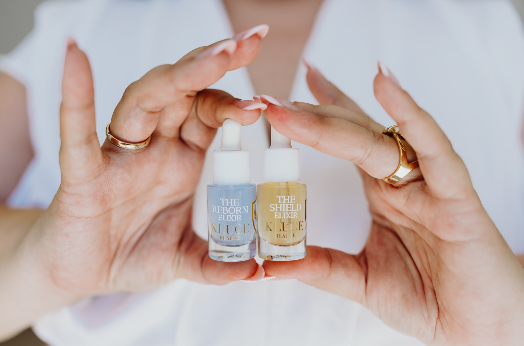 Zwei Serum-Flakons von KLUGE BEAUTÉ, gehalten in Nadines Händen